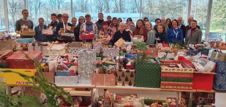 Fröhliche Weihnachten für alle, Freude kann man schenken, über 800 Weihnachtspäckchen konnten an Bedürftige verteilt werden: Schirmherr Landrat Manfred Müller (fünfter von links), Uwe Hoffmann, Vorsitzender der Tafel Paderborn ((hinten, elfter von links, Schulleiter des Edith-Stein-Berufskollegs, Wilfried Lappe (dritter von rechts), Angelika Friede, Lehrerin am Gymnasium St. Michael (vierte von links), die Ehrenamtlichen der Tafel Paderborn sowie Schülerinnen und Schüler des Edith-Stein-Berufskollegs und des Gymnasiums St. Michael Paderborn in der Mensa des Edith-Stein-Berufskollegs in Paderborn. Bildnachweis: Amt für Presse- und Öffentlichkeitsarbeit, Kreis Paderborn, Michaela Pitz Weihnachtspäckchenaktion der Tafel Paderborn